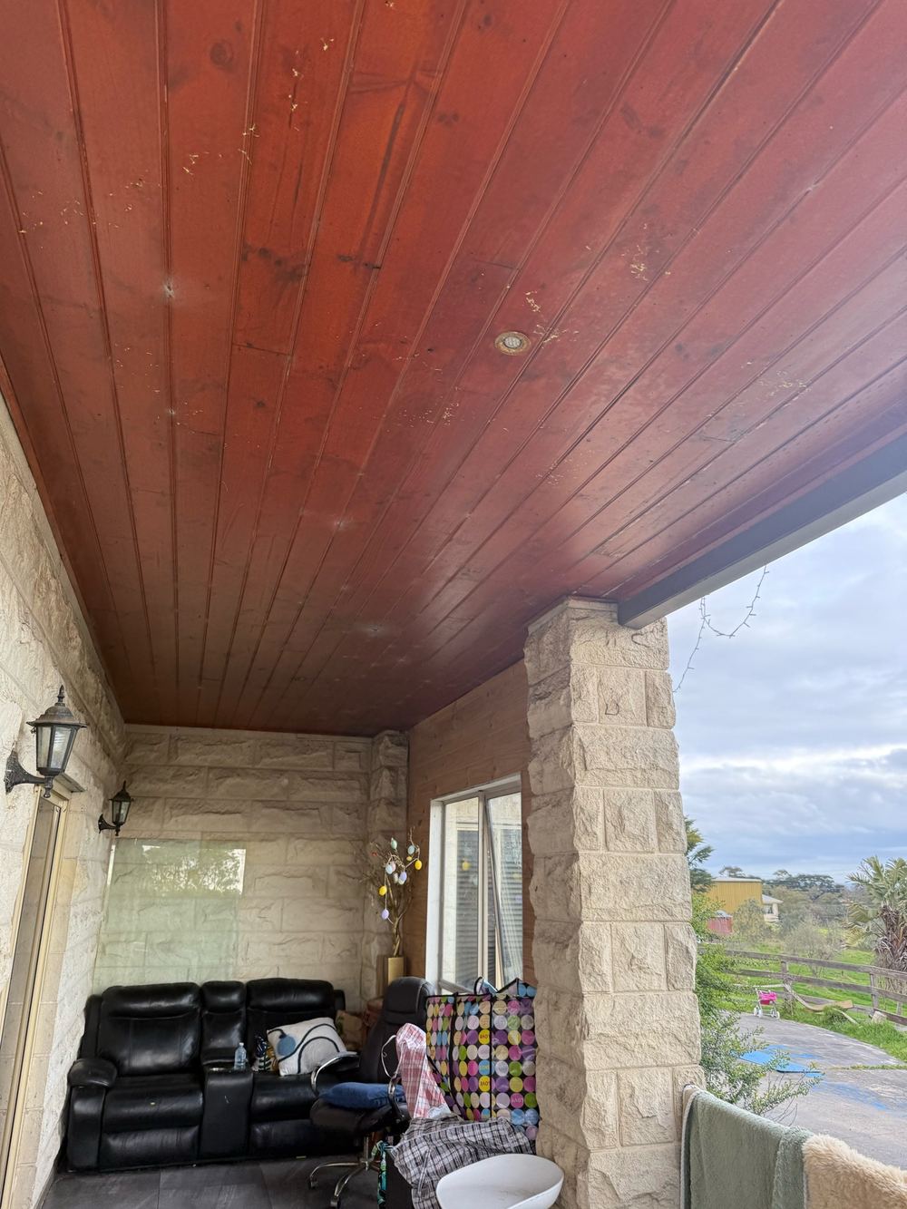 Timber soffit lining under the balcony breaking down from weather and moisture, found during a defect investigation inspection in Officer