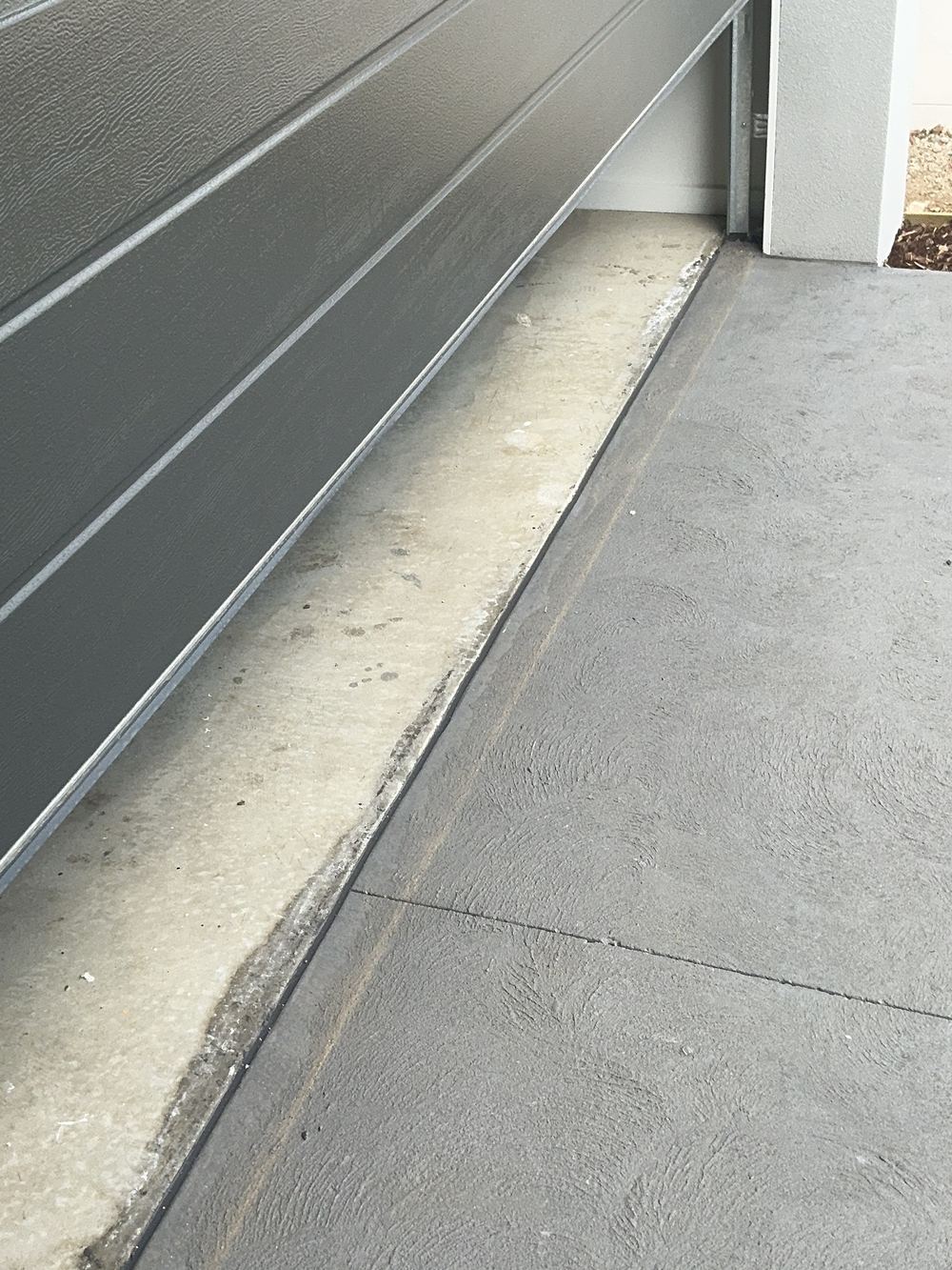 No isolation joint where the driveway concrete meets the house slab, found during a pre-handover inspection in Officer