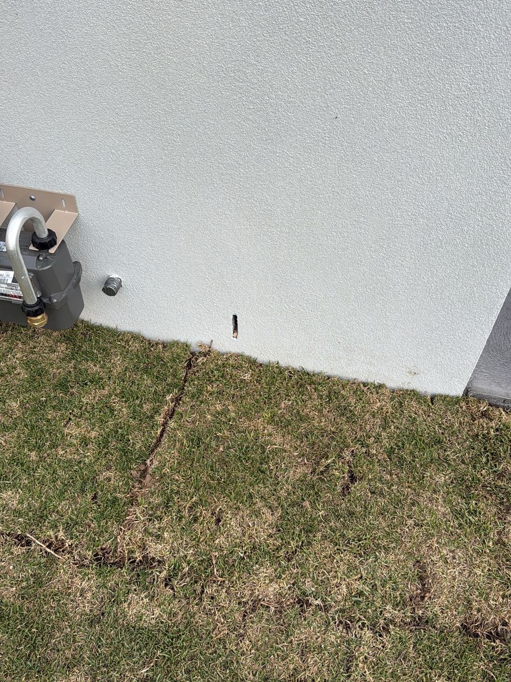 Ground built up too close to the weep holes, below the clearance required, found during a pre-handover inspection in Officer